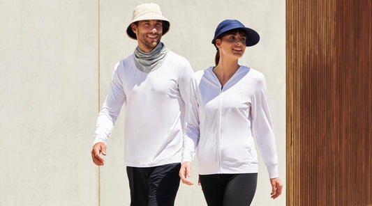 A woman and a man wearing Solbari sun hats and UPF 50+ clothing, walking.