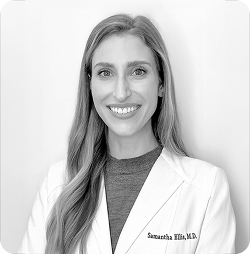 Black and white photo of a woman wearing a white lab coat with 'Samantha Ellis, M.D.' on it.