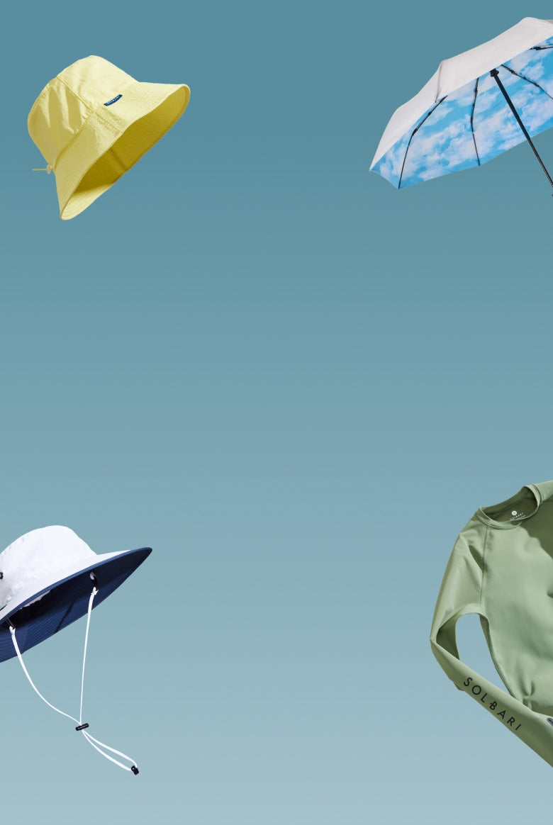 Hats, a top and an umbrella floating on a light blue background.