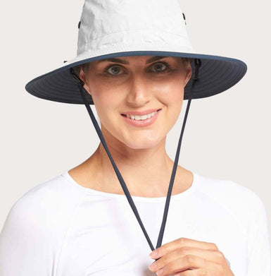 A woman wearing a white hat with a navy neck cord.