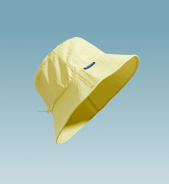 A yellow sun hat floating on a light blue background.