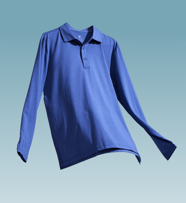 A dark blue long sleeve polo shirt floating on a light blue background.