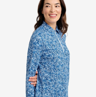 Woman wearing a blue and white patterned shirt on a plain background