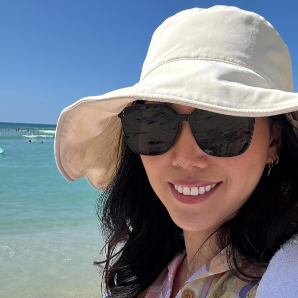 A woman in sunglasses and a Solbari hat.