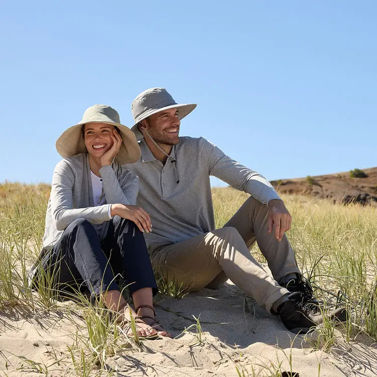 Woman and men sitting on a hill wearing Solbari sun hats and clothing.
