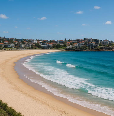 Bondi Beach scene with clear blue sky, turquoise water, and houses in the background.